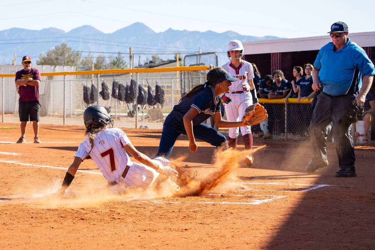 Pahrump Valley High School junior Riley Saldana slides into home safely, evading the tag from T ...