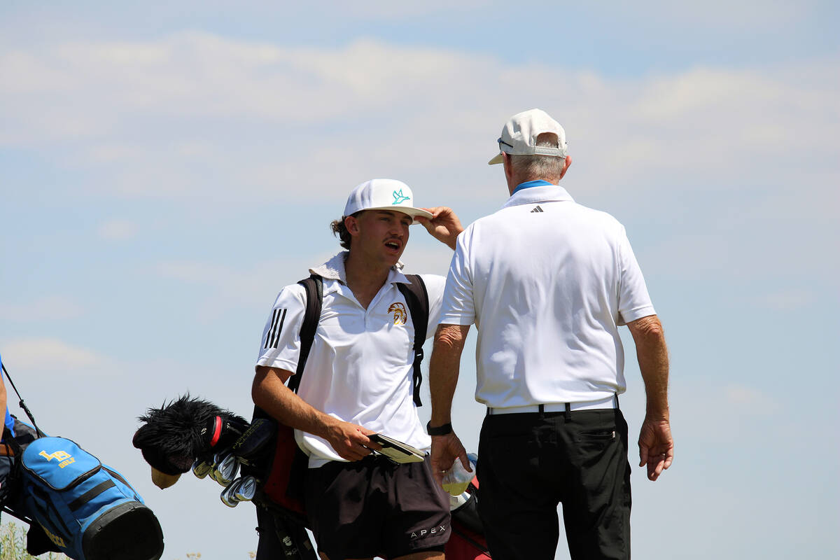Pahrump Valley High School boys golf junior Travis Floyd and head coach Bob Hopkins share a wor ...