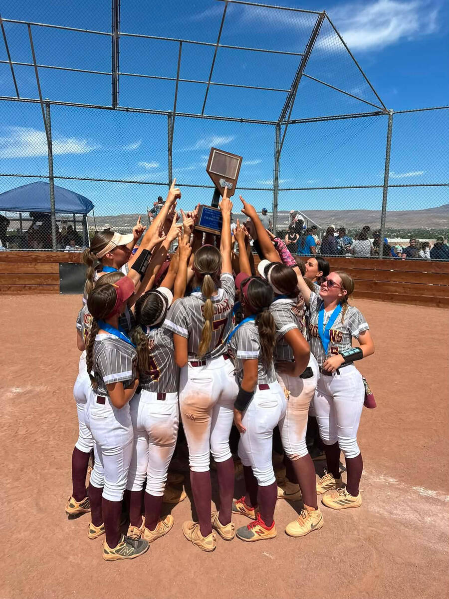 The Pahrump Valley High School varsity girls softball program hoists a trophy above their heads ...