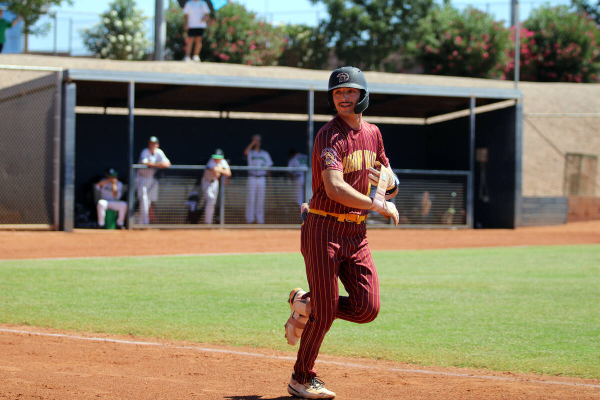 Pahrump Valley High School senior Kayne Hoibe smiles as he takes a jog to first base following ...