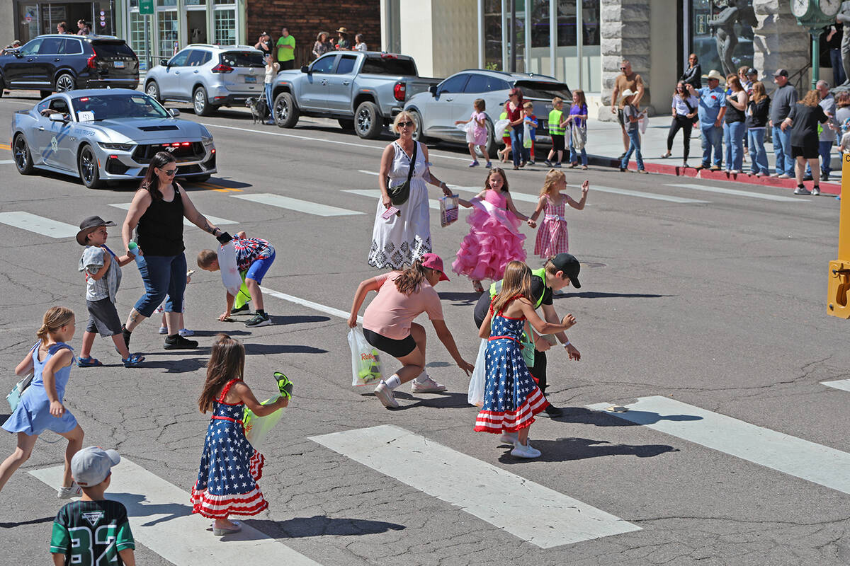 Youngsters race into the street to grab candy and other items tossed by Jim Butler Days Parade ...