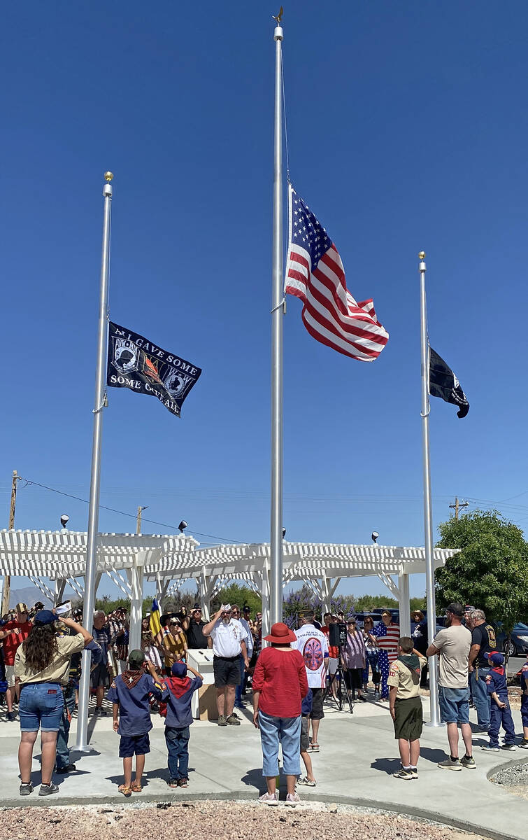 Attendees of the VFW Post #10054's Memorial Day Ceremony salute the flags as they are raised to ...