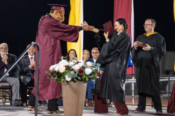 Graduates share a special hug, handshake or dance with Pahrump Valley High School’s Principal ...