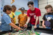 4-H Robotics member Dexter Aguilar helps instructs students during the FIRST LEGO League summer ...