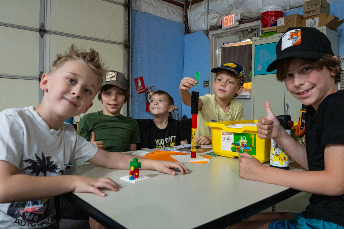 Multiple youth campers participate in a Lego building project during the FIRST LEGO League summ ...