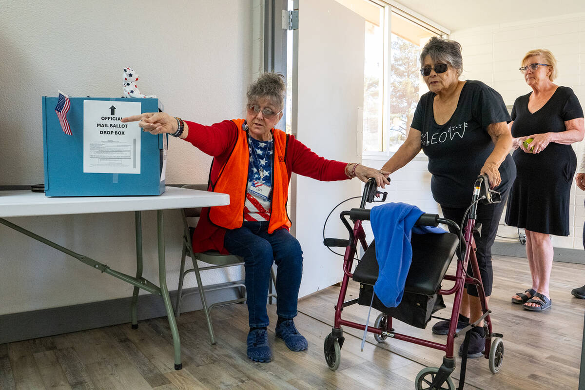 Poll workers at the front entrance of Bob Ruud Community Center guided people to the check-in a ...