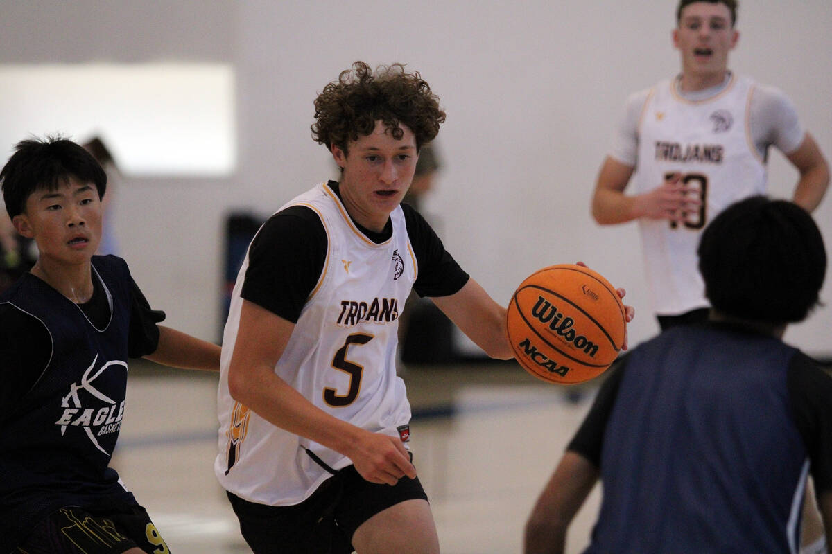 Pahrump Valley High School basketball player Evan Strain dribbles through traffic against Lake ...