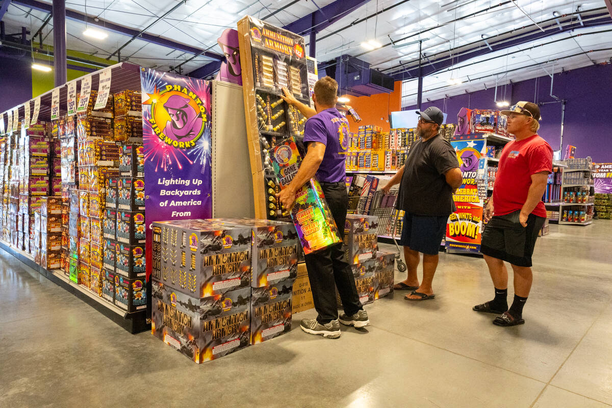 A Phantom Fireworks employee shows customers a large product filled with aerial mortars, called ...