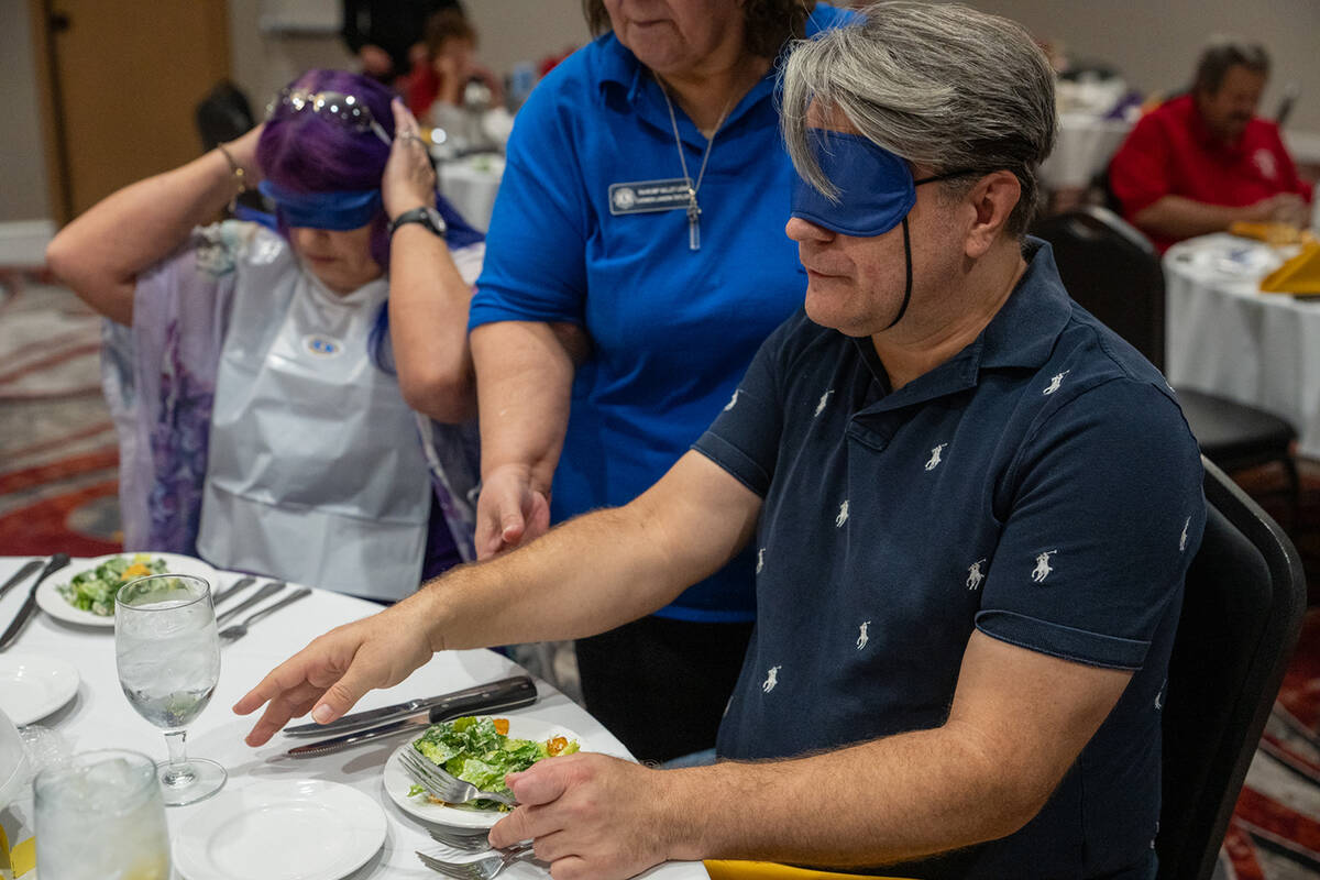 A Dinner in the Dark attendee carefully searched for his silverware before digging into the sal ...