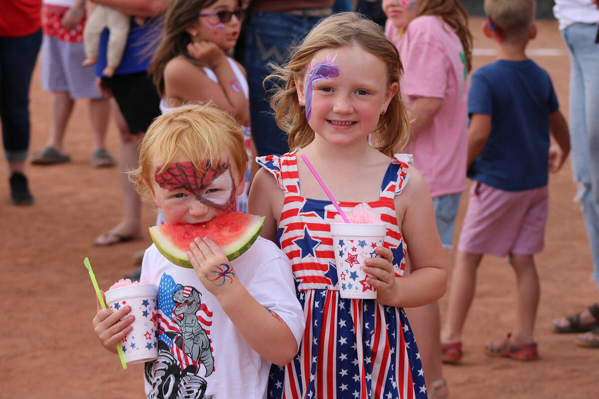 Janis Wilson's grandson digs into a piece of watermelon while his sister grins for the camera d ...