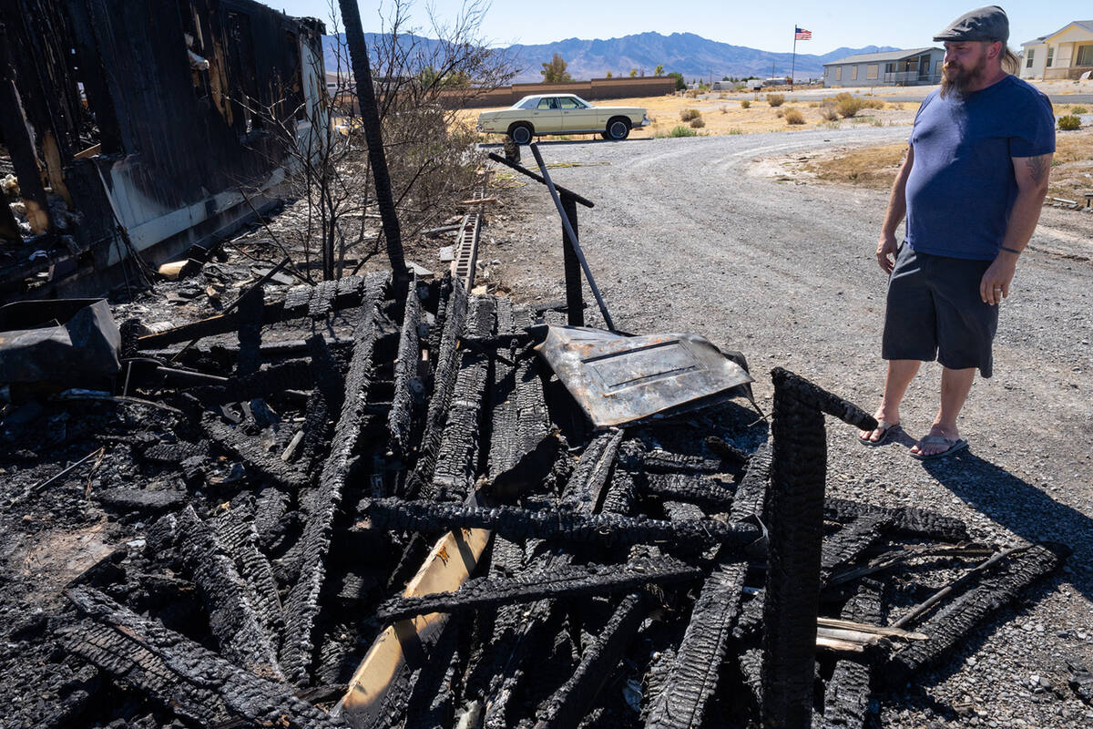 Jacob Pennell stands next to what was formerly his home's front porch, where he first saw the f ...