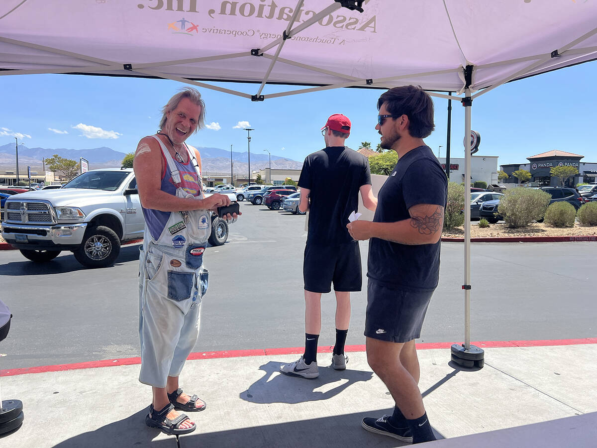 With a wide grin, a local resident reaches into his wallet to pull out a cash donation to suppo ...
