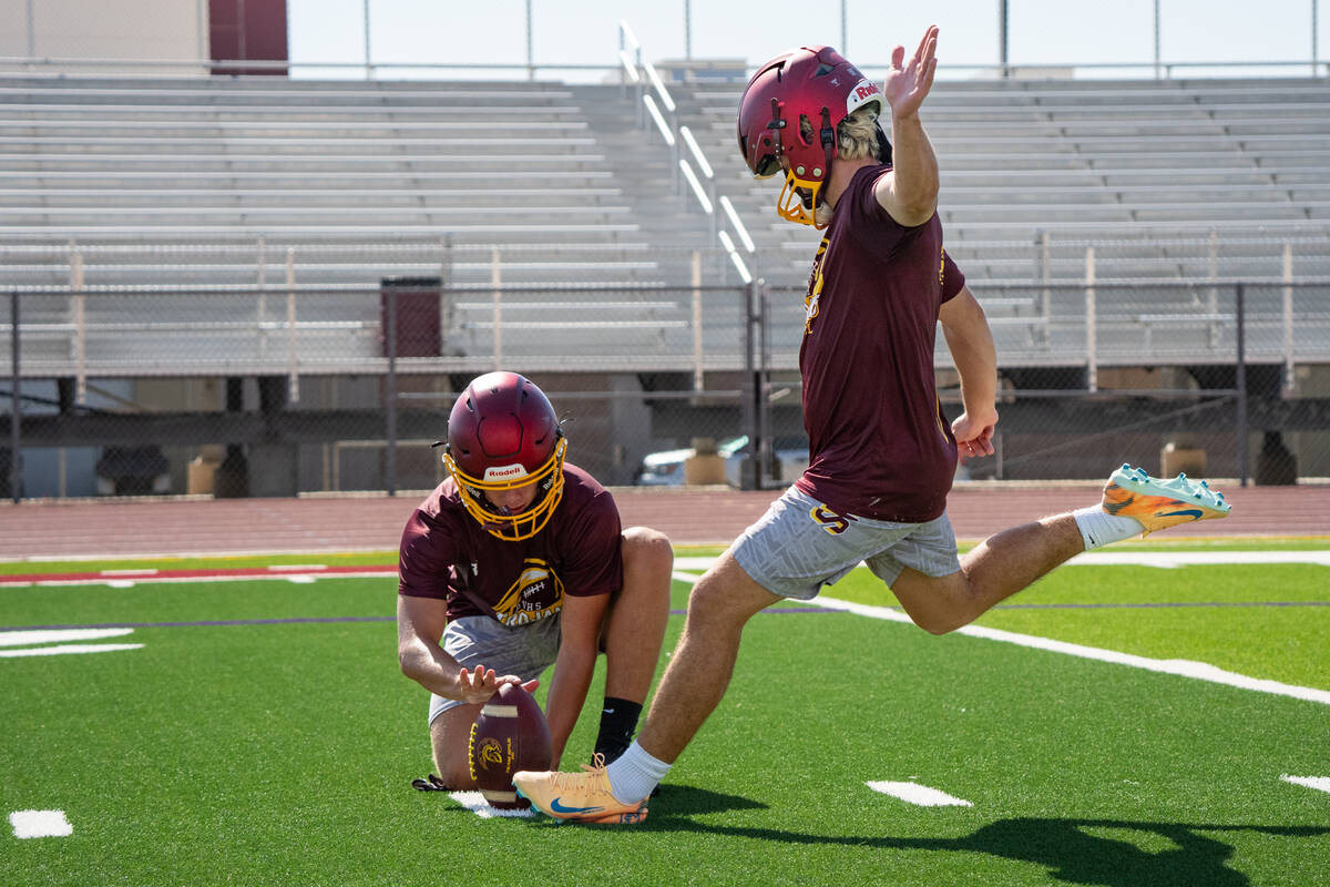 Kicker Aaron Riley, left, and holder Hunter Wydick work on field goals during football practice ...