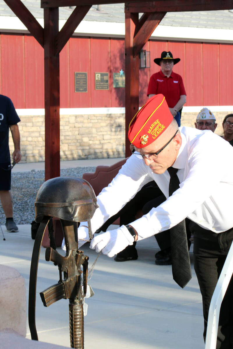 As part of the Purple Heart Day Sundown Ceremony, veteran Joe Gent carefully places the metal I ...