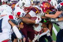 Pahrump Valley’s Iyan Bosket fights for yardage as Providence Hall defenders converge during ...