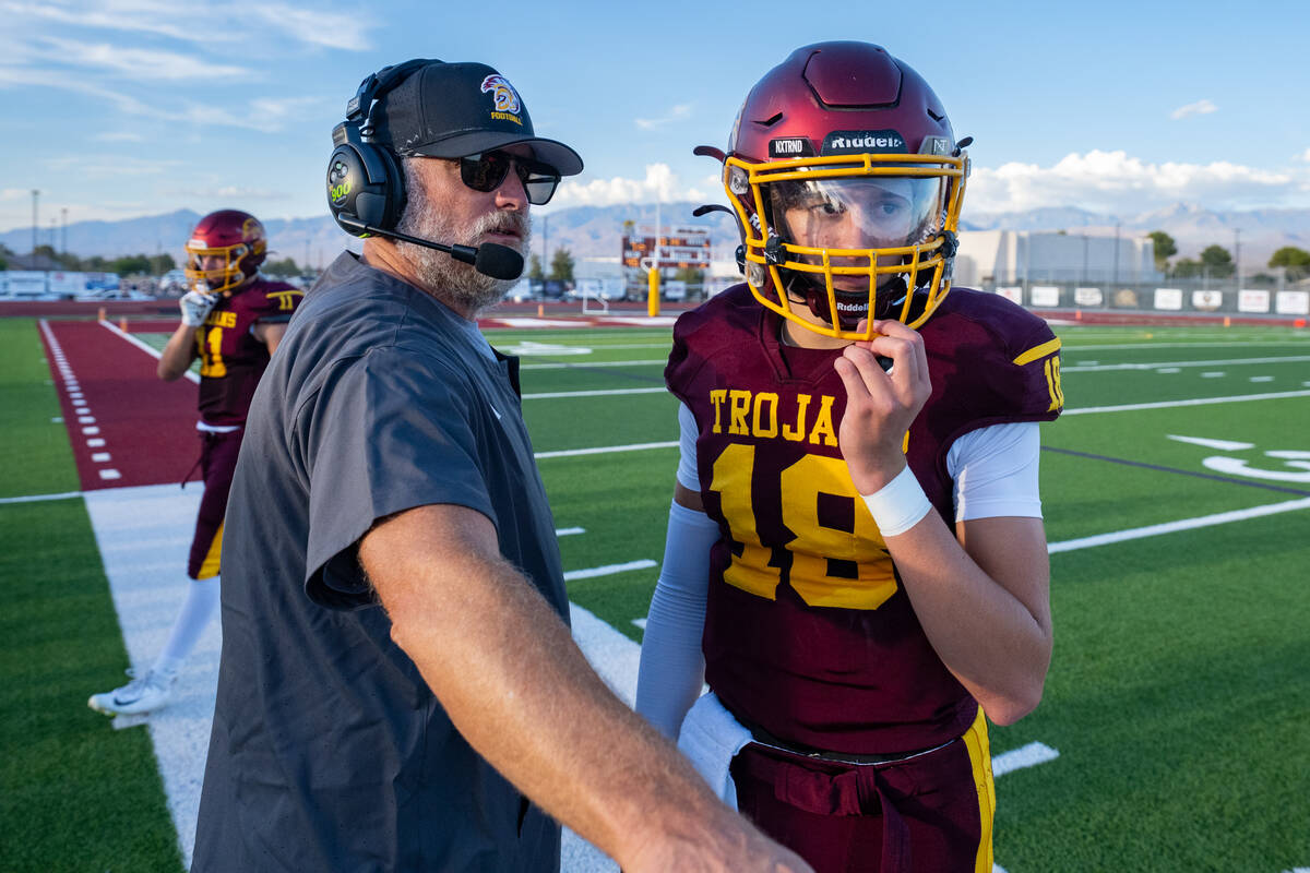 Pahrump Valley head coach Toby Henry and sophomore quarterback Evan Strain confer on the sideli ...