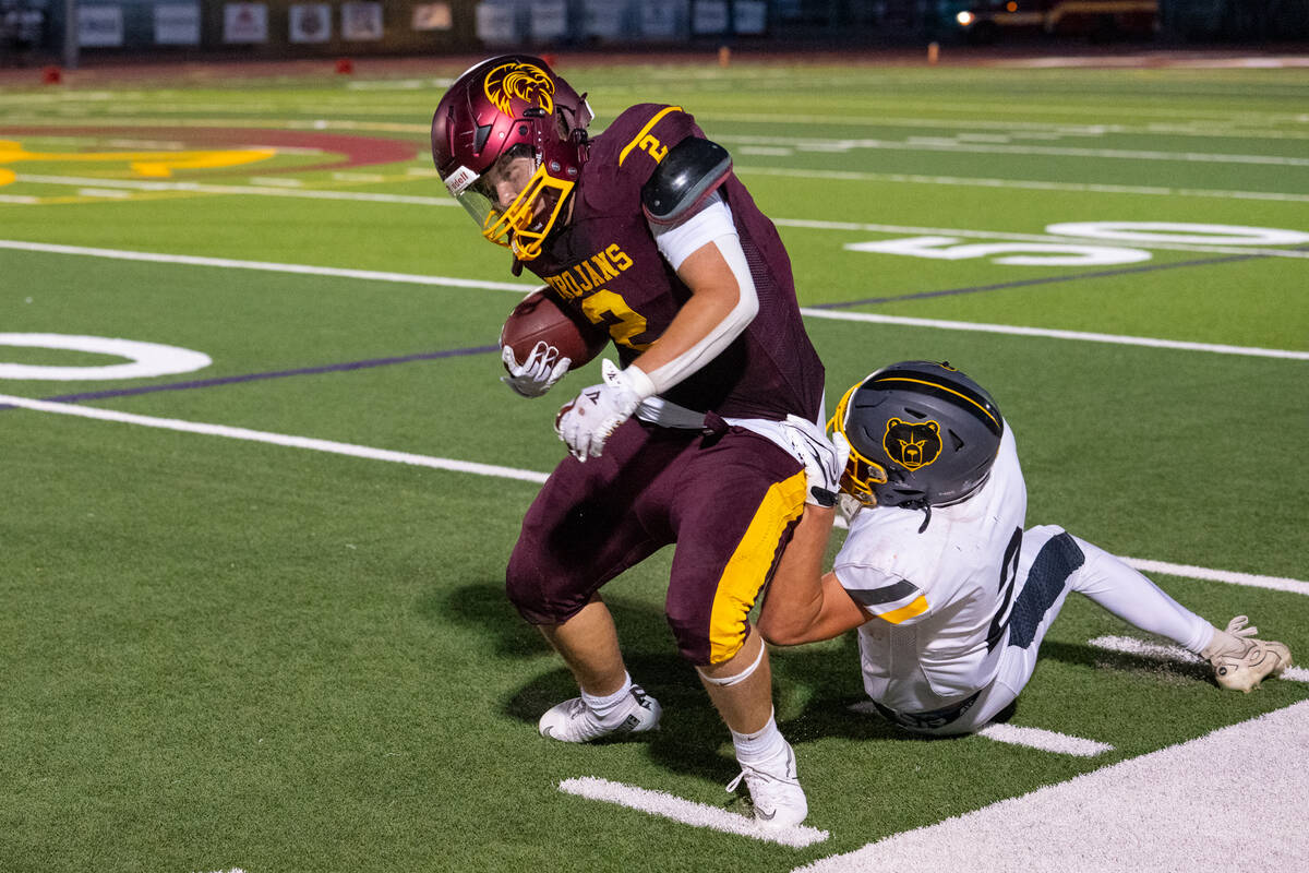 Pahrump Valley senior running back Preston Dockter tries to stay on his feet as a Galena defend ...