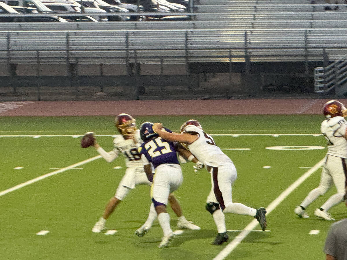 Pahrump Valley quarterback Ryan Hamlin gets a pass away as Durango pressure closes in during th ...