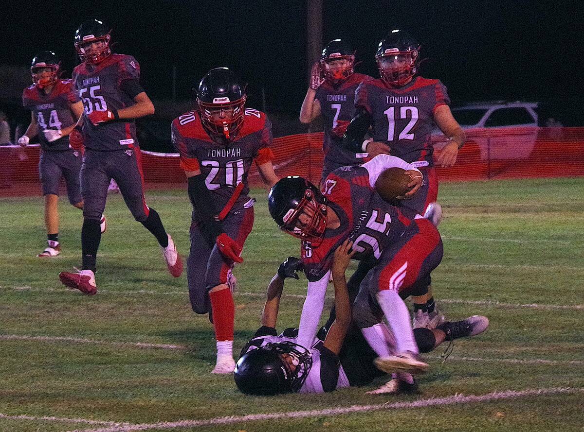 Tonopah defenders swarm a Round Mountain ballcarrier as seniors Levi Harhay (12) and Tristan Fi ...