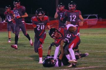 Tonopah defenders swarm a Round Mountain ballcarrier as seniors Levi Harhay (12) and Tristan Fi ...