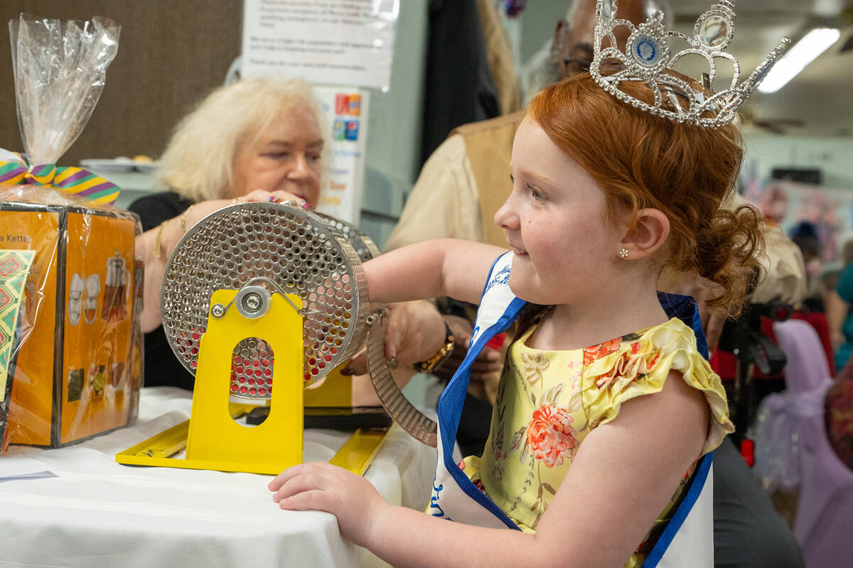 A young Nye County Cinderella Girl reaches into a hopper to pull out a winning raffle ticket at ...