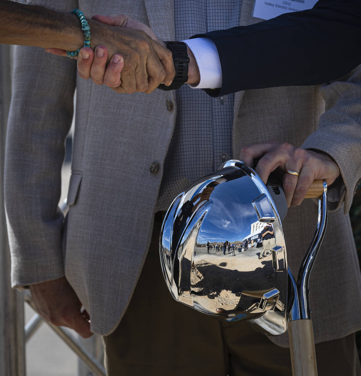 Officials shake hands following a groundbreaking ceremony for GridLiance West, which will see n ...