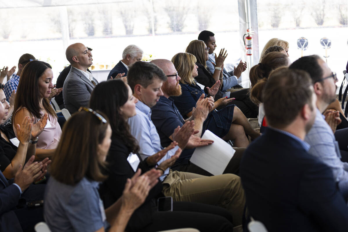 Attendees clap during a groundbreaking ceremony for GridLiance West, which will see new and upg ...