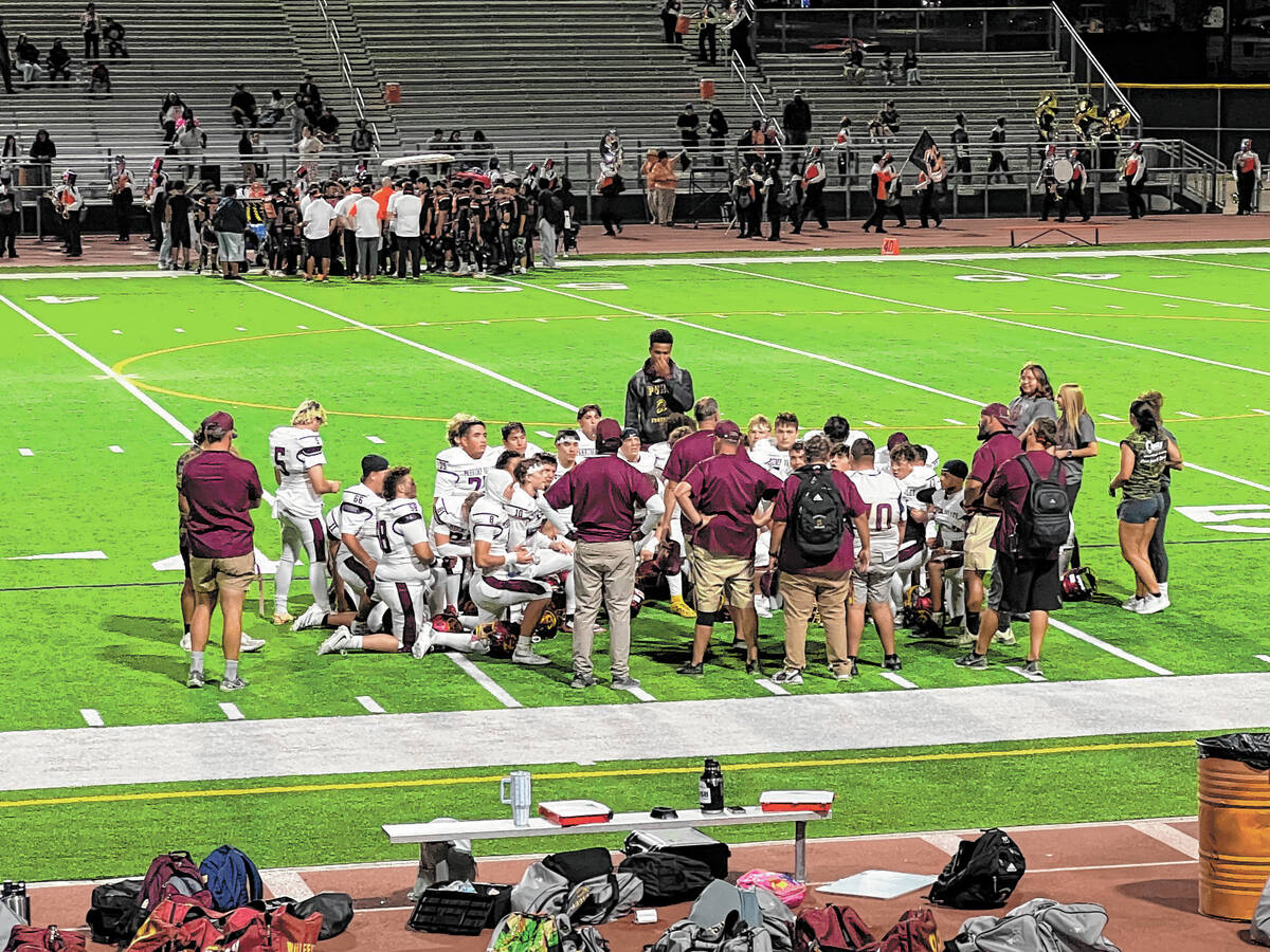 Pahrump Valley players gather around their coaches during the Sept. 4 game at Chaparral. The Tr ...