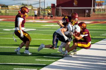 Pahrump Valley’s Paul Walker (22) and Kobe Farmer (21) tackle a Providence Hall ball carrier ...