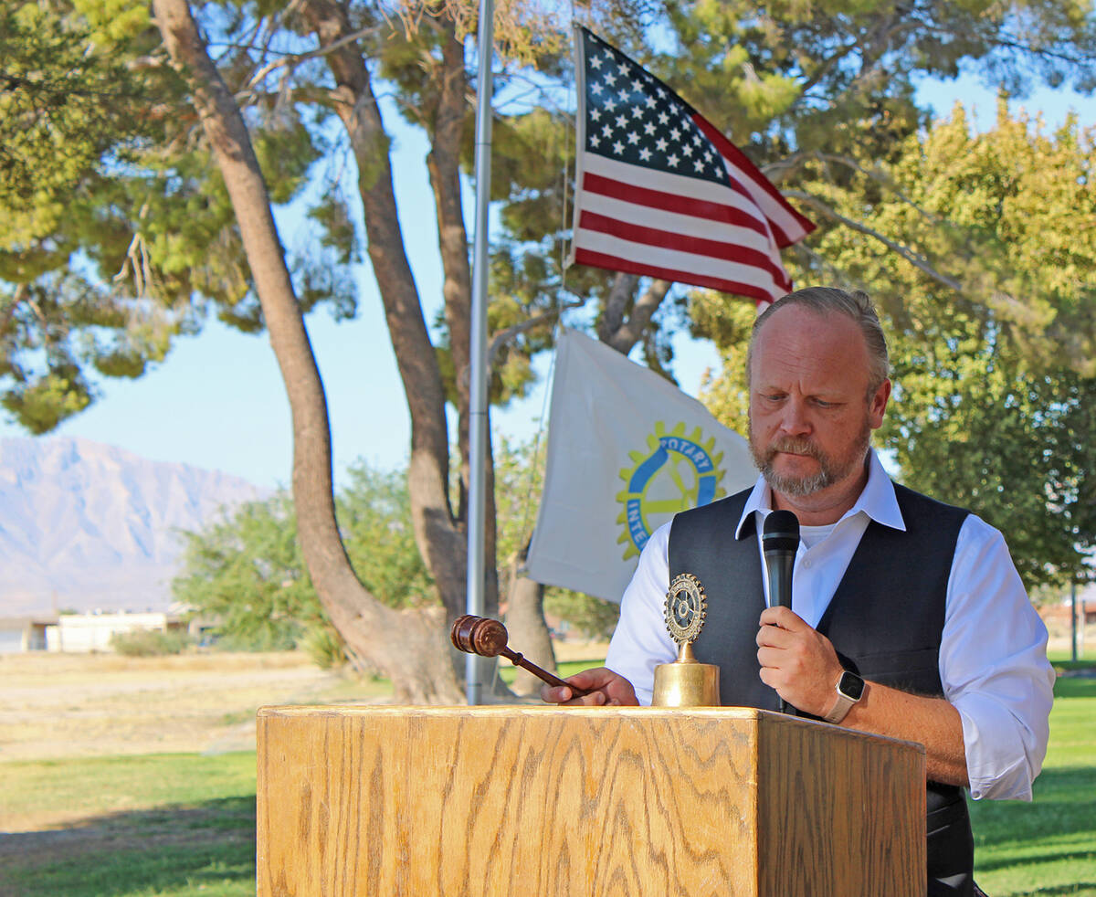 Rotarian Jeffrey Dye strikes a bell in honor of the moment when each of the four planes involve ...