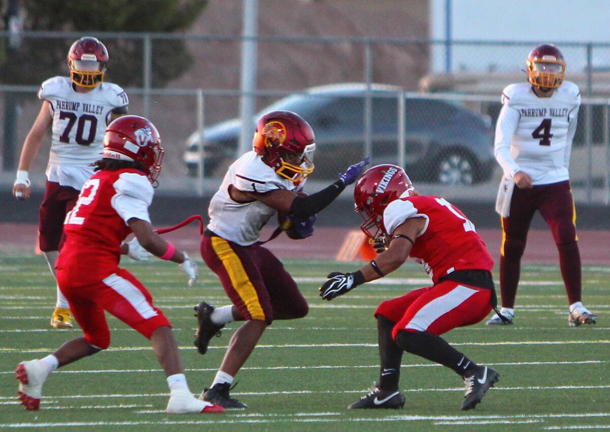 Pahrump Valley’s Angel Ware extends an arm toward a Valley defender while carrying the footba ...
