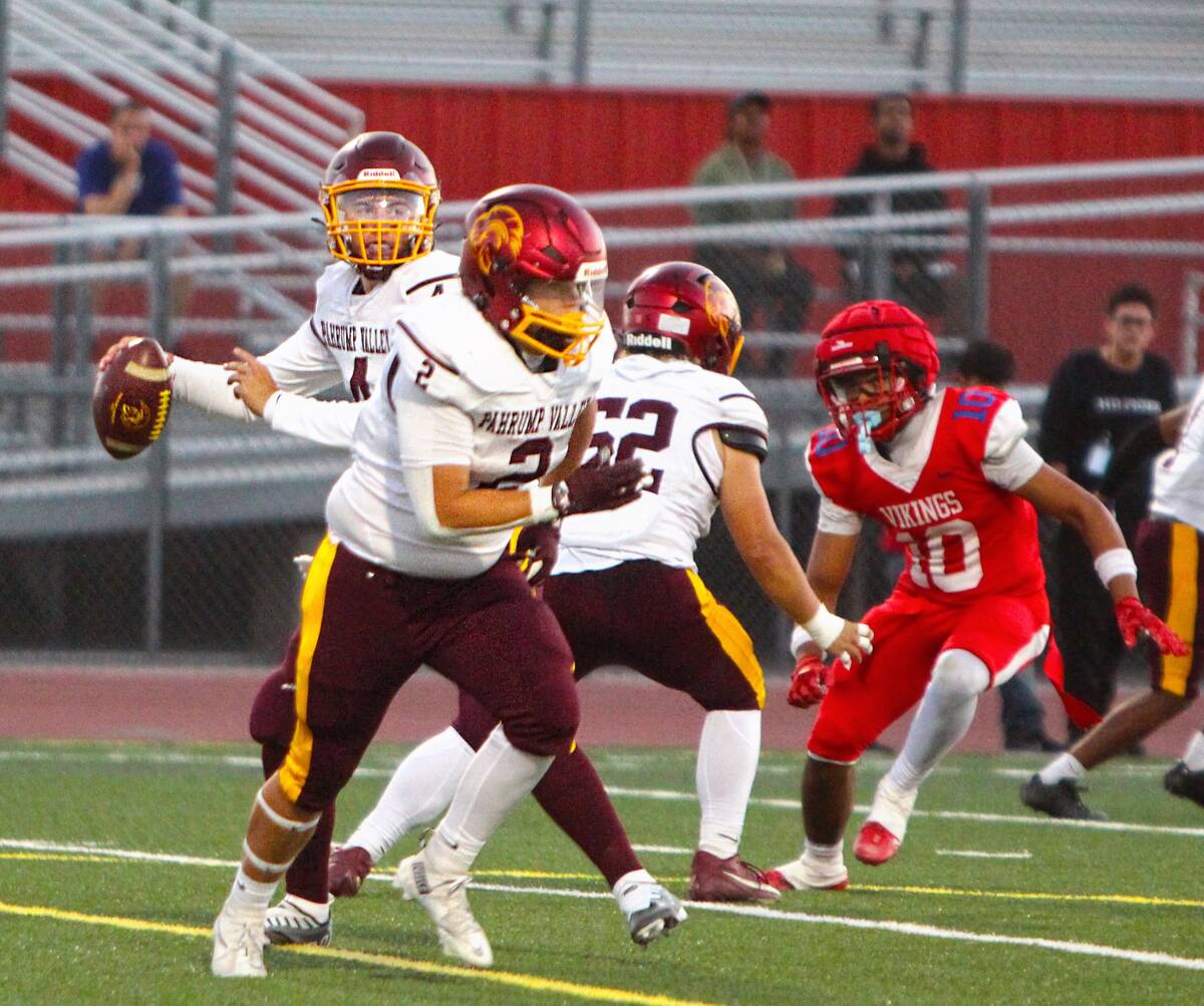 Pahrump Valley sophomore quarterback Wyatt Cross prepares to throw as Preston Dockter (2) moves ...