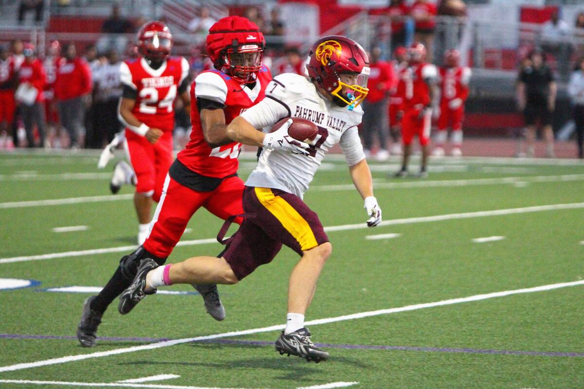 Pahrump Valley’s Ryan Hamlin carries the ball as a Valley defender pursues him during the Tro ...