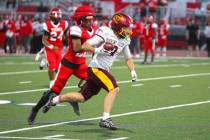 Pahrump Valley’s Ryan Hamlin carries the ball as a Valley defender pursues him during the Tro ...