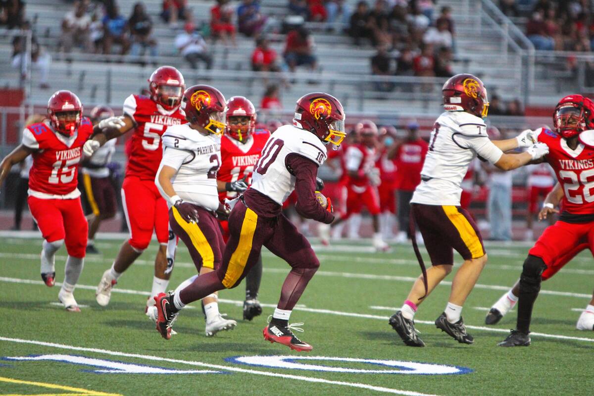 Pahrump Valley’s Lucas Gavenda (10) carries the ball while Ryan Hamlin (7) blocks and Preston ...