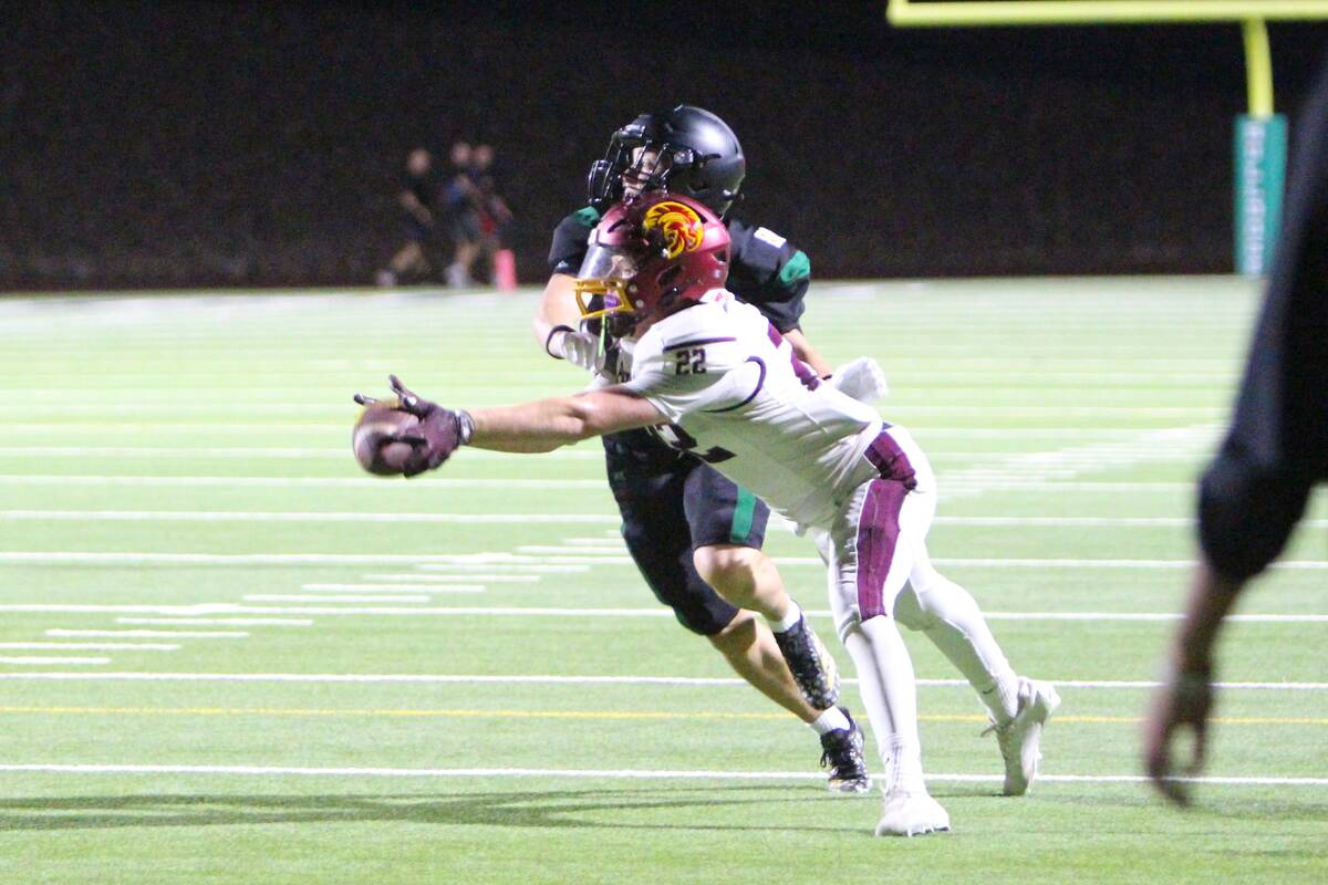 Pahrump Valley’s Paul Walker reaches for a pass with a Virgin Valley defender nearby during t ...