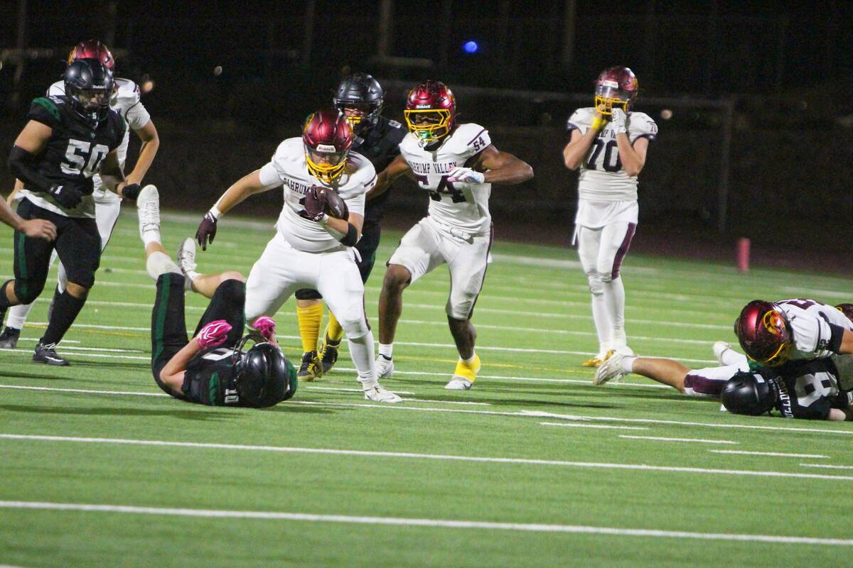 Pahrump Valley’s Preston Dockter carries the ball past a fallen Virgin Valley defender as tea ...