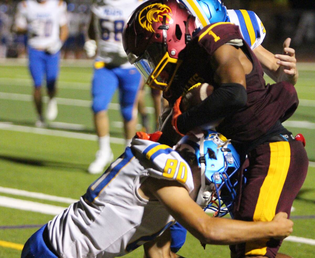Pahrump Valley’s Angel Ware protects the ball as Moapa Valley defenders wrap him up during th ...