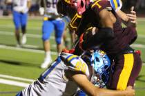 Pahrump Valley’s Angel Ware protects the ball as Moapa Valley defenders wrap him up during th ...