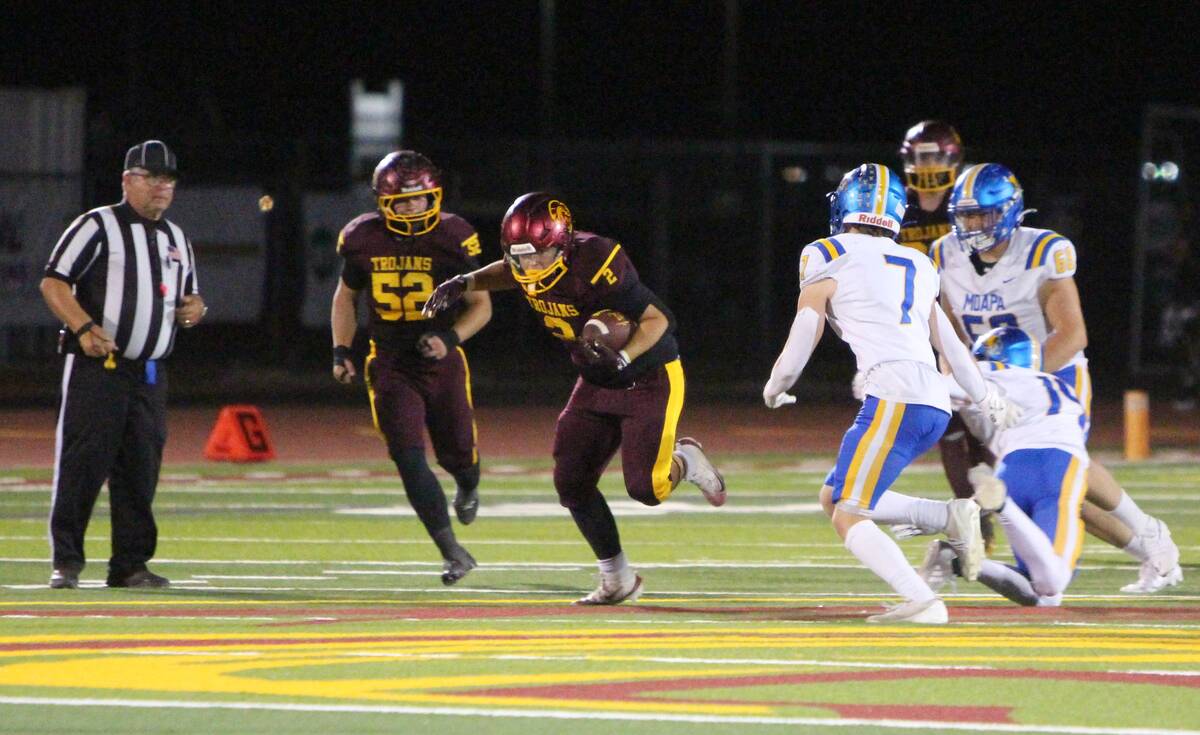 Pahrump Valley running back Preston Dockter carries the ball as Moapa Valley defenders close in ...
