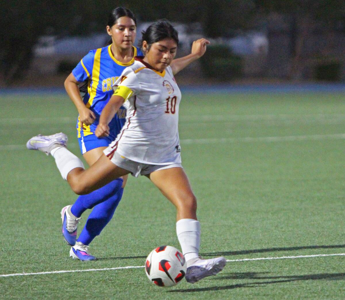 Pahrump Valley’s Paola Aguilar (10) prepares to kick the ball with a Cristo Rey defender clos ...