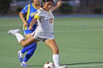 Pahrump Valley’s Paola Aguilar (10) prepares to kick the ball with a Cristo Rey defender clos ...